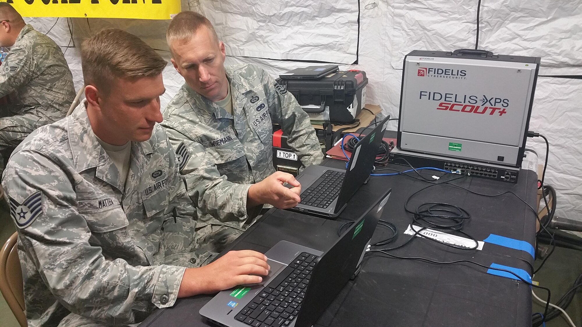 Intelligence Analysts Staff Sgt. Donovan Mattea and Tech. Sgt. Kelly Wiemann both of the 960th Network Warfare Flight, discuss network traffic while embedded within the 35th Combat Communications Squadron's simulated deployed environment at Homestead Air Reserve Base, Fla.