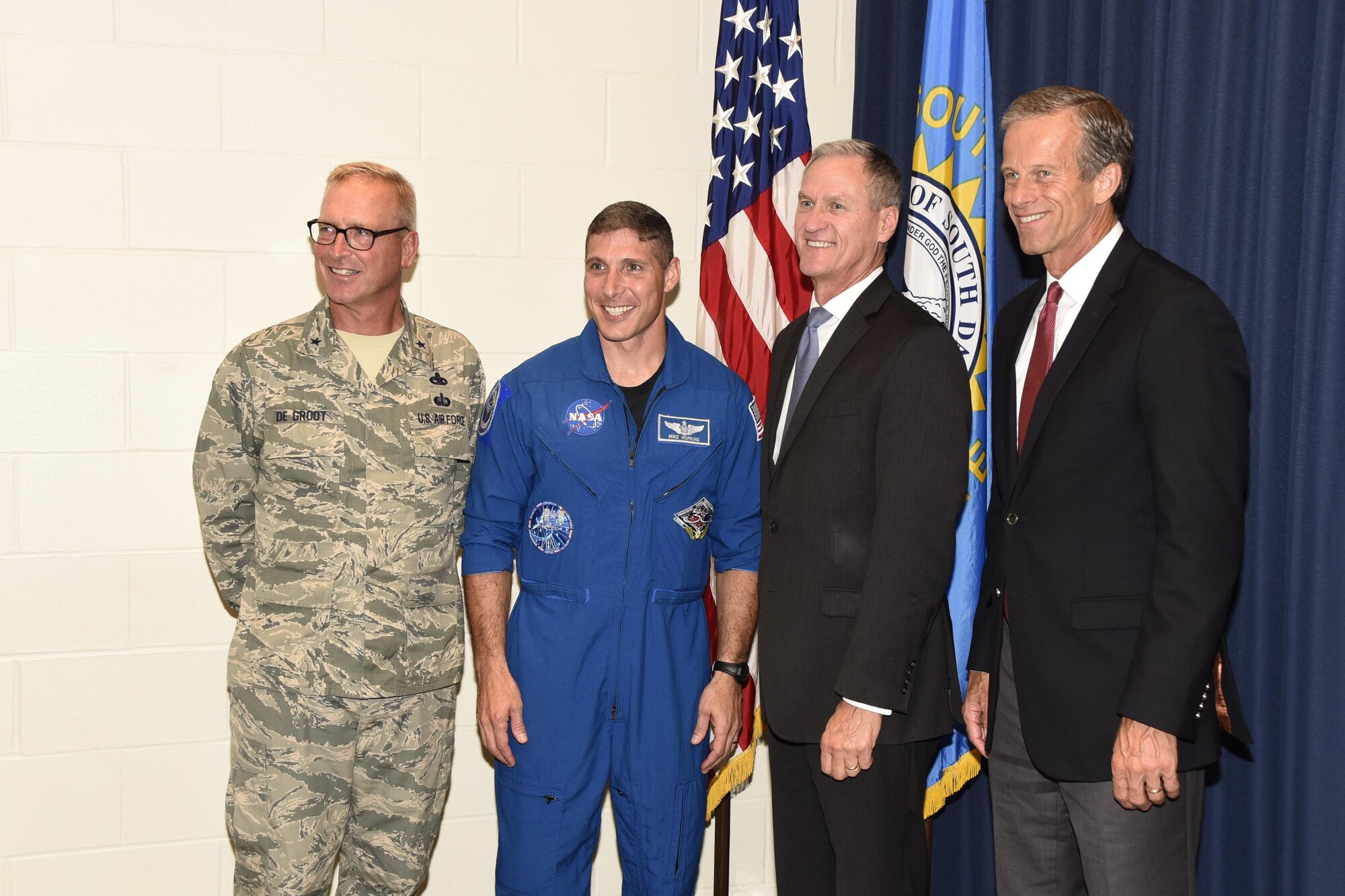 Colonel Michael Hopkins, NASA Astronaut, posed for a photo with Brig. Gen. Joel De Groot, SDNG assistant adjutant general for air, Gov. Dennis Daugaard, and U.S. Sen. John Thune here, Aug. 4.  Hopkins shared his experiences as an astronaut with members of the 114th Fighter Wing.  (U.S. Air National Guard photo by Master Sgt. Christopher Stewart/Released)