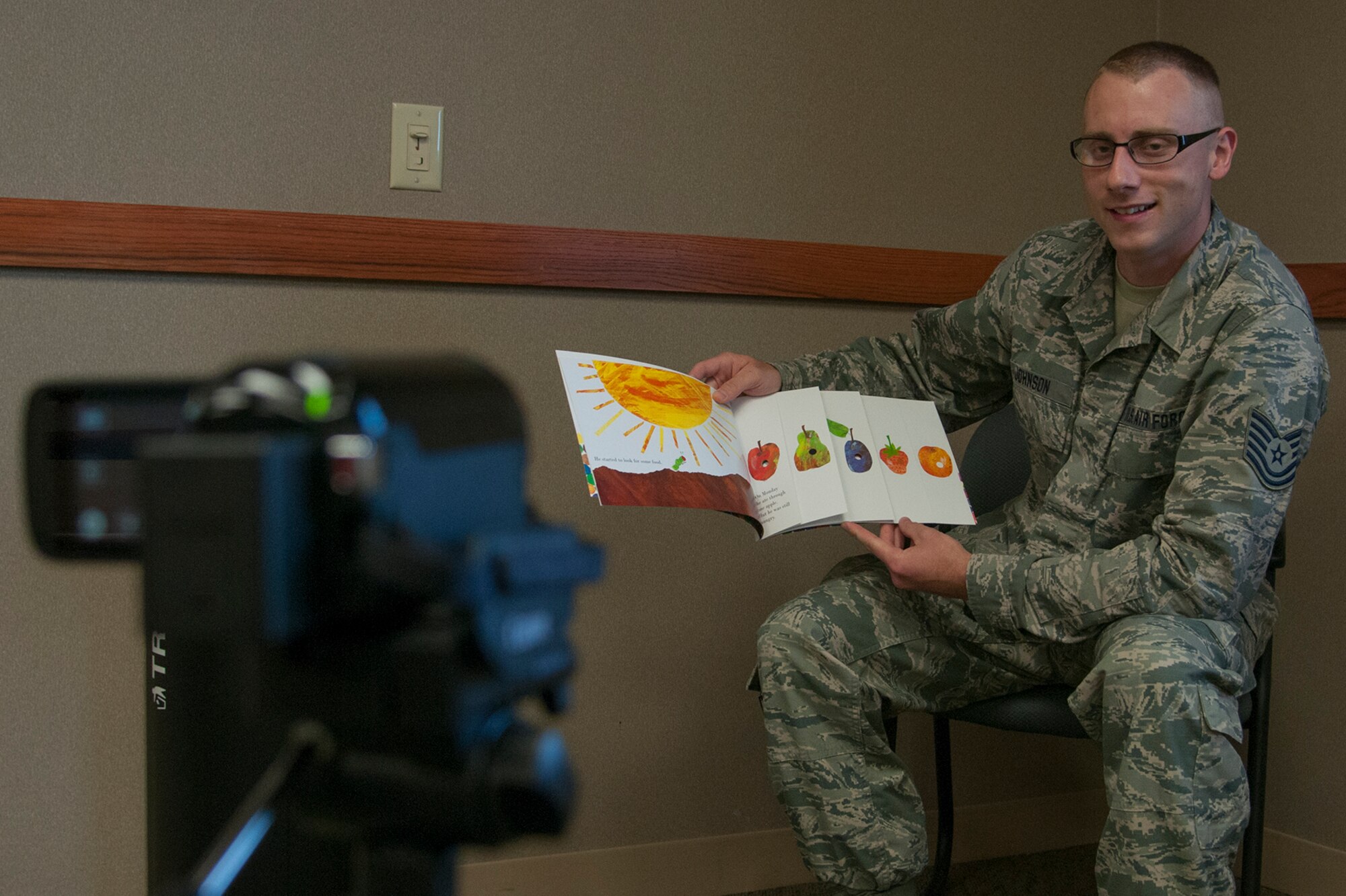 Tech. Sgt. Jeffrey Johnson, 434th Maintenance Squadron nondestructive inspection craftsman, reads a book for his daughter as part of the United Through Reading program at Grissom Air Reserve Base, Indiana on August 5, 2017. The recording of him reading is burned to a CD which he can give to his family to watch while he is away from home. (U.S. Air Force photo/Staff Sgt. Dakota Bergl)
