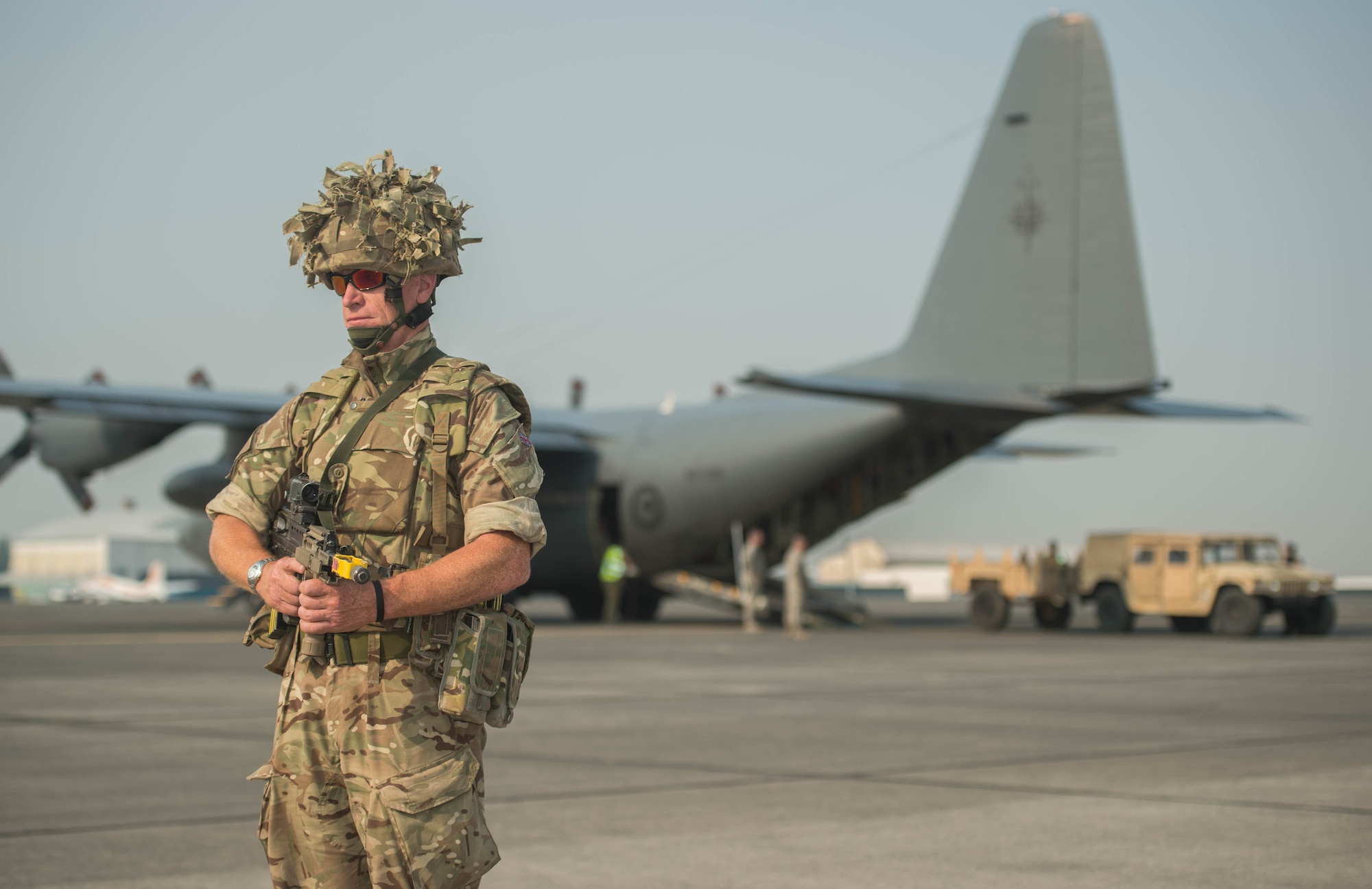 Royal Air Force aircraftsman in full uniform for exercise is standing on the flightline