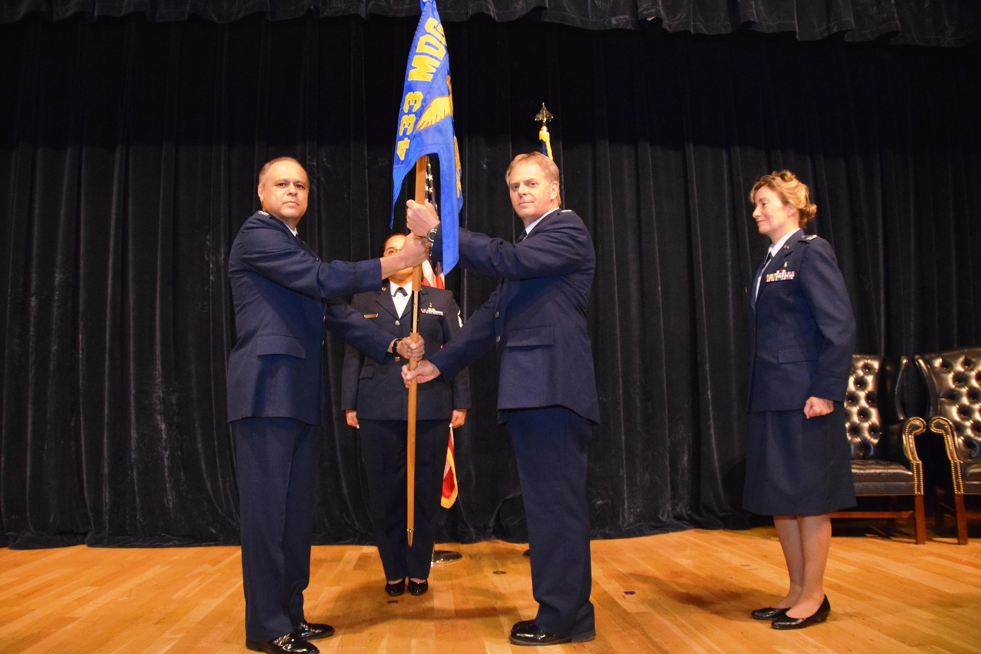 Col. Ernest Vasquez, 433rd Medical Group commander, passes the 433rd Aerospace Medicine Squadron guidon to the new squadron commander, Col. Paul B. Deschner, during an assumption of command ceremony at Joint Base San Antonio-Lackland, Texas,  Aug. 6, 2017.