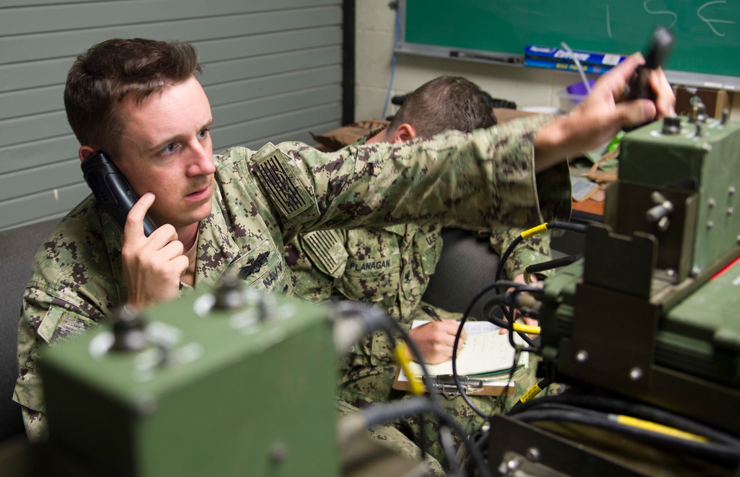 Electronics Technician 2nd Class Anthony Juarez and Electronics Technician 3rd Class Codie Flanagan, assigned to Naval Mobile Construction Battalion (NMCB)1,  adjust frequency codes on a GRC-234 high-frequency base station at Naval Base Guam July 27, 2017. These tests give NMCB 1 Sailors the opportunity to perform quality assurance checks on their system’s maximum range and communication quality with Port Hueneme, Calif. NMCB 1 provides expeditionary construction and engineering support to expeditionary bases and responds to humanitarian assistance disaster relief requests.