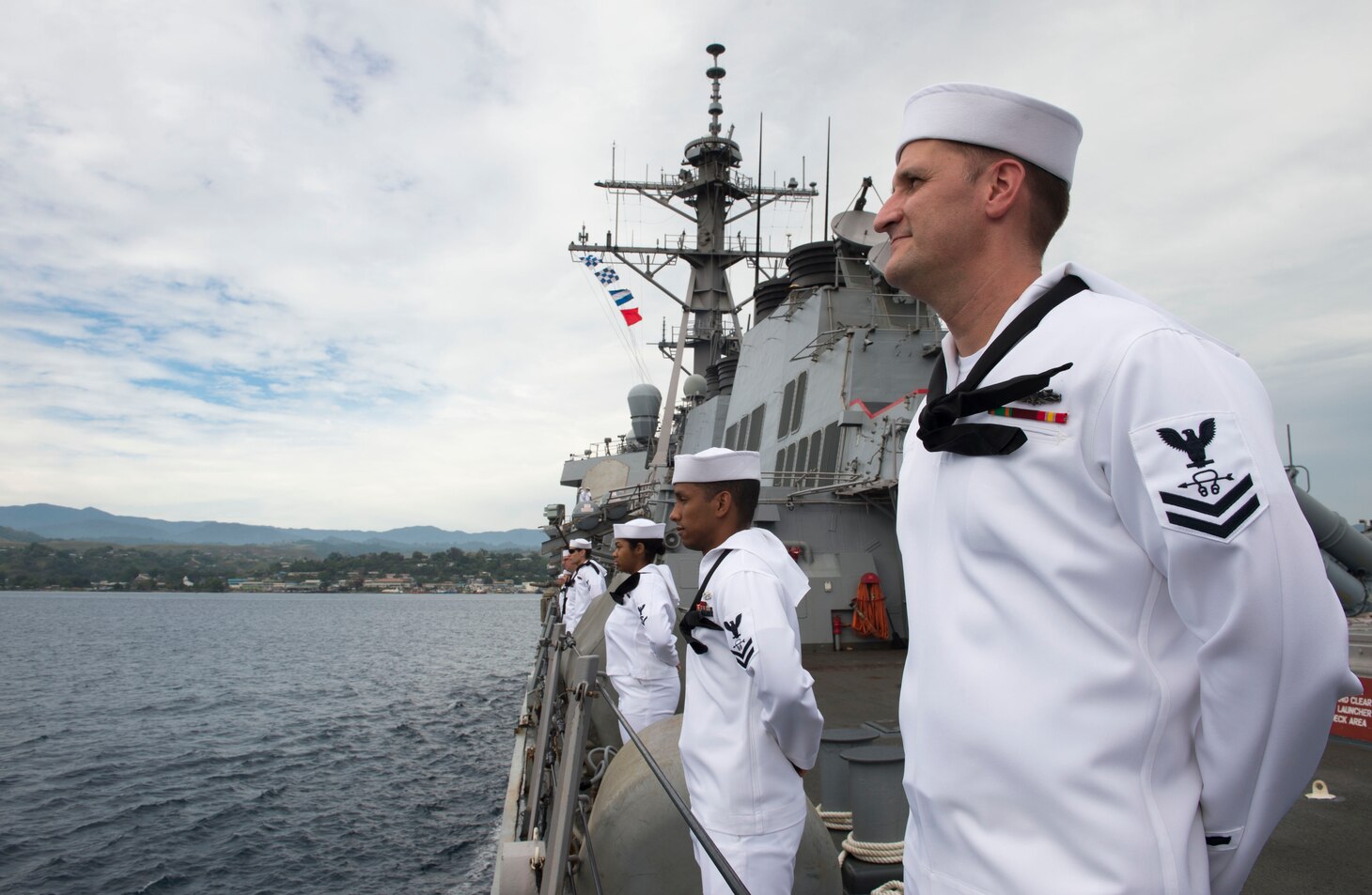 Sonar Technician (Surface) 2nd Class Matthew Fryer, assigned to the Arleigh Burke-class guided-missile destroyer USS Barry (DDG 52), stands at parade rest while pulling into Guadalcanal for a port visit to commemorate the 75th anniversary of the Guadalcanal Campaign. The 75th commemoration is a tribute to the courage, service, and sacrifice of those who fought in the Guadalcanal Campaign of World War II.
