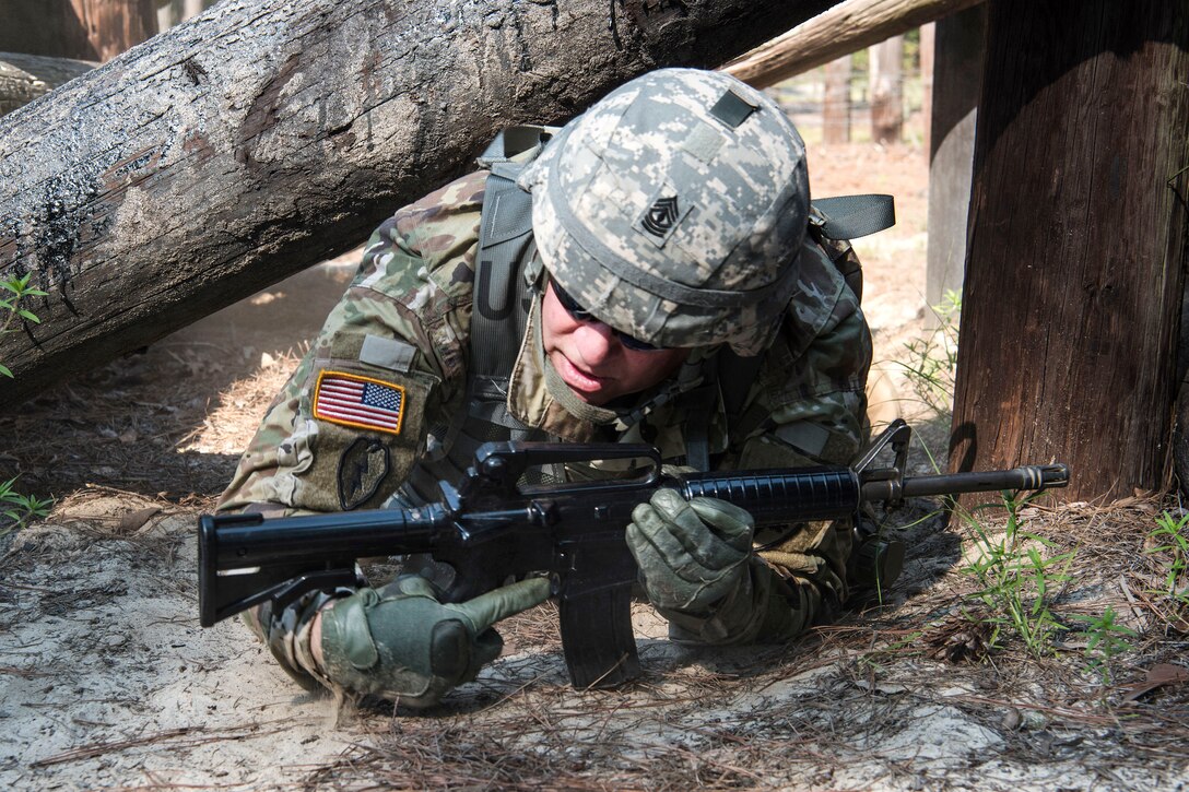 A soldier low crawls participating in pre-deployment training.