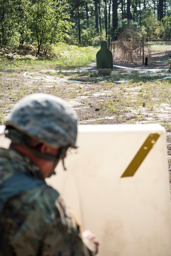 A soldiers prepares to to fire his weapon at a target during pre-deployment training.