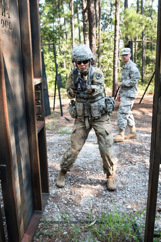 A soldier prepares to enter and search a building during pre-deployment training.
