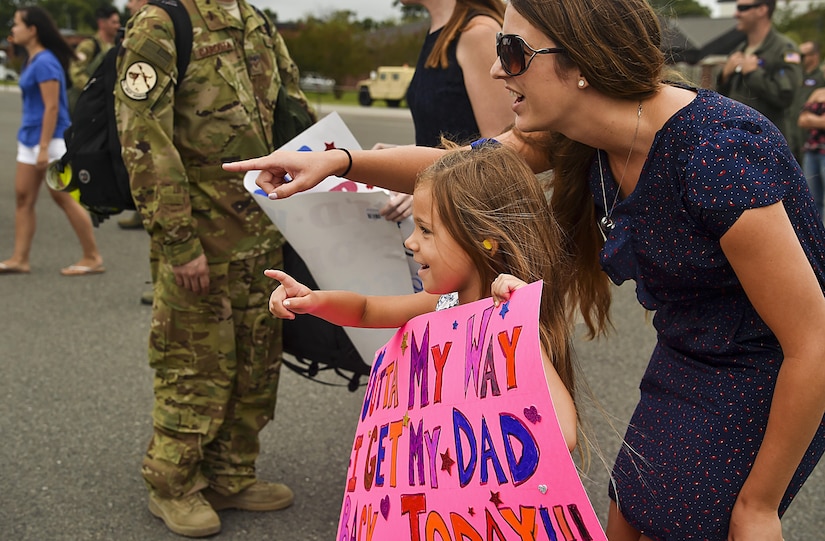 Hailey Fatjo, left, and Stacey Fatjo, right, wife and daughter of a returning Charleston deployer, point in excitement as he gets off a plane at Joint Base Charleston, S.C., Aug. 8, 2017.