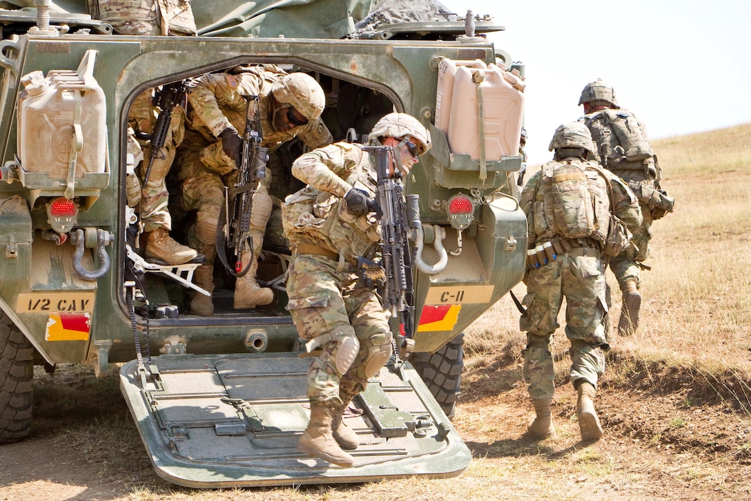 Soldiers exit a M1126 stryker combat vehicle.