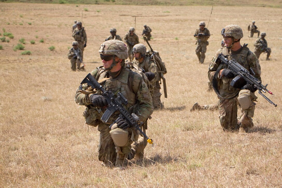 Soldiers wait for follow on orders before moving to their next objective on a dismounted patrol.
