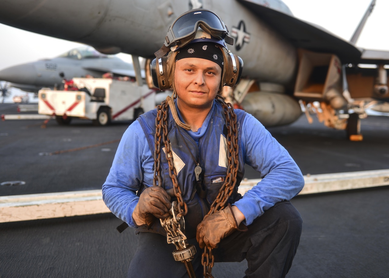 Sailor holds chains on aircraft carrier flight deck
