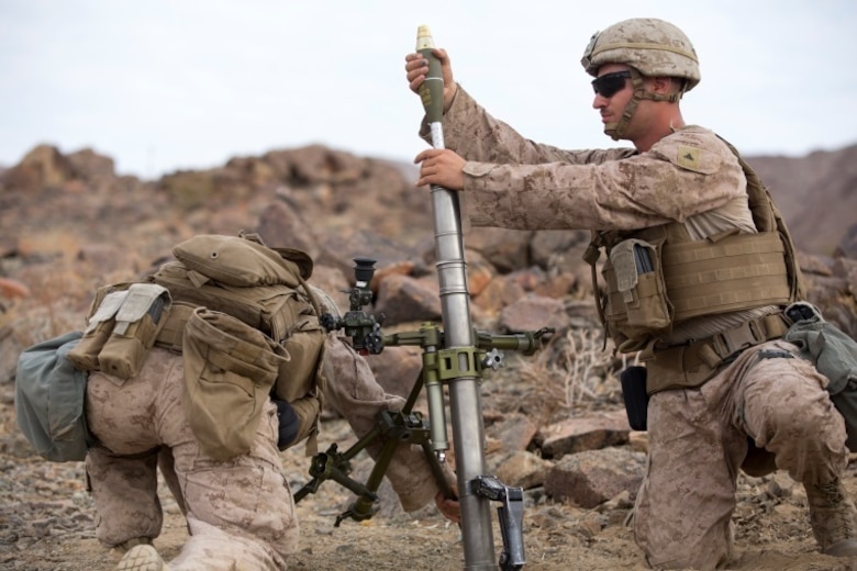 Lance Cpl. Kyle Hollenback, mortarman, 1st Battalion, 1st Marine Regiment, loads a while Pfc. Sean Carlson, mortarman, 1/1, stabilizes the stand during an individual training exercise at Range 410A aboard the Marine Corps Air Ground Combat Center, Twentynine Palms, Calif., July 25, 2017. 1/1 is based out of Marine Corps Base Camp Pendleton, and is serving as part of the GCE during ITX 5-17. (U.S. Marine Corps photo by Pfc. Margaret Gale)