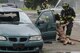 Firefighters from the 788th Civil Engineer Fire Department pull a mannequin from the vehicle after a staged major crash during a base exercise at Wright-Patterson Air Force Base, Ohio, Aug. 4, 2017. Readiness exercises are routinely held to streamline unit cohesion when responding to emergencies. (U.S. Air Force photo by Wesley Farnsworth/Released)