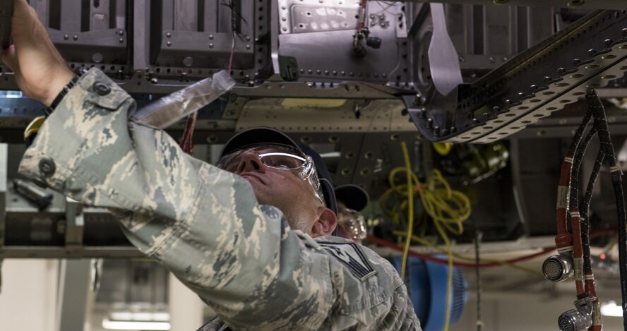 Senior Master Sgt. Travis Patterson, the 389th Aircraft Mantenance Unit lead production superintendent, examines the underside of an unfinished F-15E Strike Eagle on the production floor of a defense contractor's factory in St. Louis, Aug. 3, 2017. The visit was an opportunity for Air Force members to see the beginning stages of products they deploy while downrange. (U.S. Air Force photo/Senior Airman Jeremy L. Mosier)