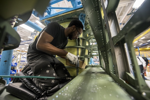 Orlando Dean, defense contractor assembly mechanic, looks over a portion of an F-15E Strike Eagle at a defense contractor's factory in St. Louis, Mo, Aug. 3, 2017. During the visit, military members were given the opportunity to meet those who create the products they use on a daily basis. (U.S. Air Force photo by Senior Airman Jeremy L. Mosier)