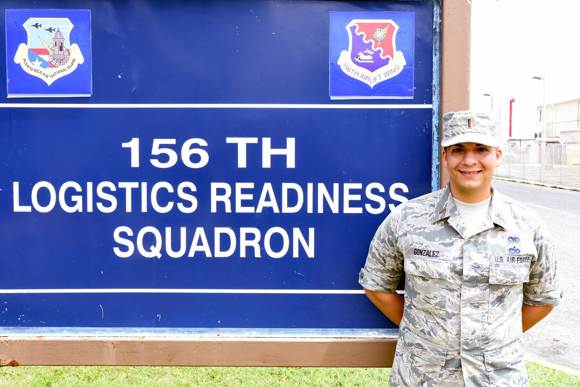 2nd Lt. Eduardo Gonzalez standing before the 156th Logistics Readiness Squadron sign.