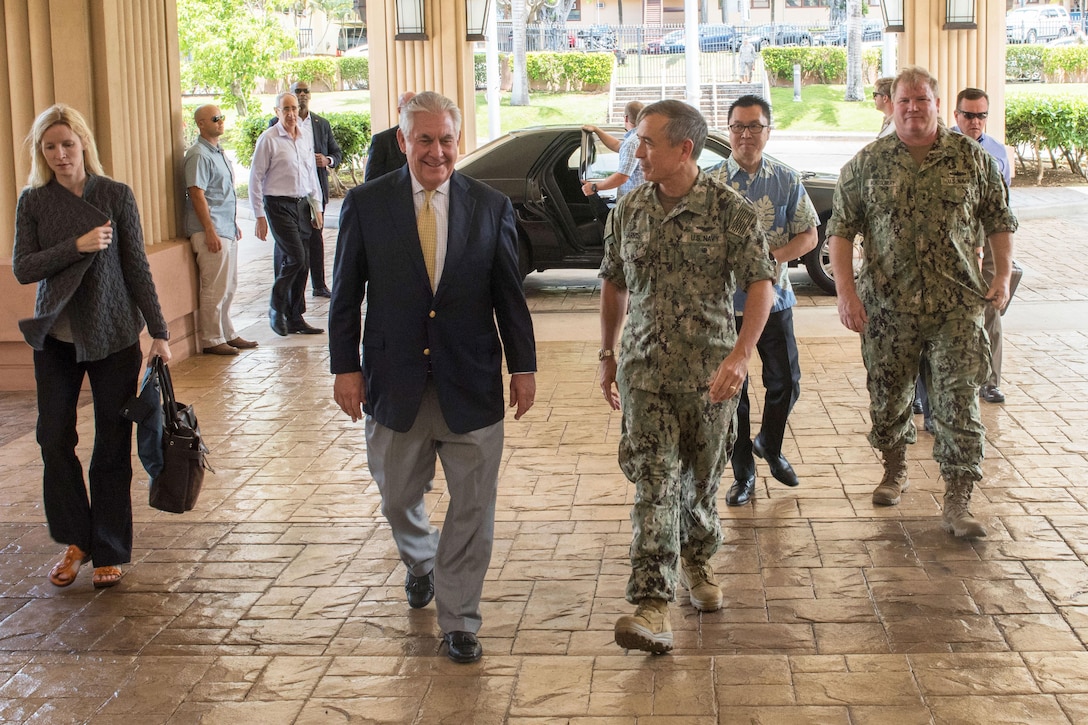 An admiral escorts the U.S. secretary of state into a command's headquarters.