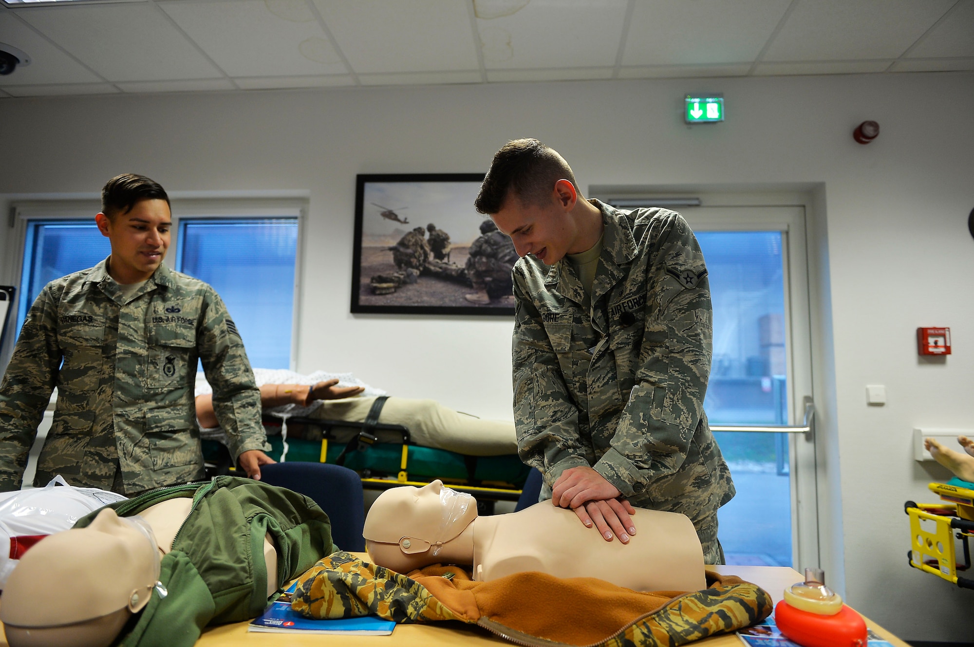 U.S. Air Force Airman 1st Class Jared Kilgore, 86th Aerospace Medicine Squadron public health technician, center, receives instructions from U.S. Air Force Staff Sgt. Joshua Vanegas, 86th Security Forces Squadron unit fitness program manager, as he practices chest compressions on a CPR training mannequin on Ramstein Air Base, Germany, Aug. 3, 2017. The 86th Medical Group conducts monthly CPR training for personnel who intend to be the CPR representatives for their units. (U.S. Air Force photo by Airman 1st Class Joshua Magbanua)