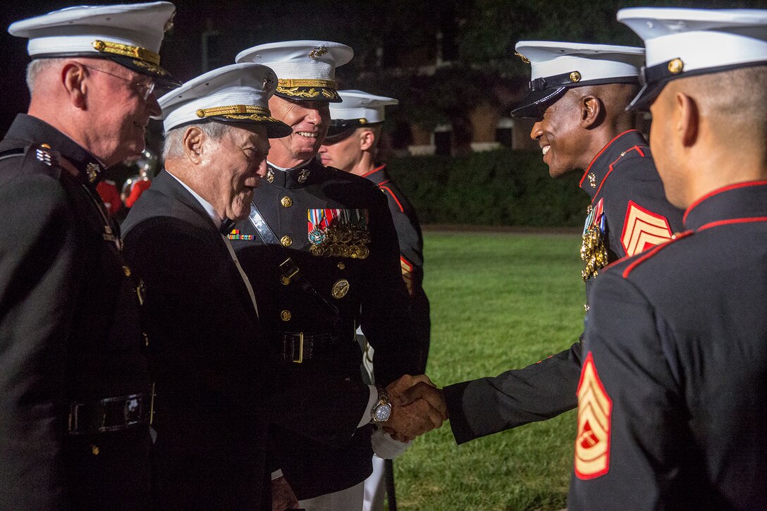 Master Sgt. Selwyn Reid, senior marcher for the staff noncommissioned officer parade staff, Marine Barracks Washington D.C., shakes hands with the guest of honor during the SNCO Evening Parade at the Barracks, Aug. 4, 2017. The guest of honor for the parade was retired Marine Corps Col. Archie Simpson, Guadalcanal veteran, and the hosting official was Lt. Gen. James B. Laster, director, Marine Corps Staff. (Official Marine Corps photo by Cpl. Robert Knapp/Released)