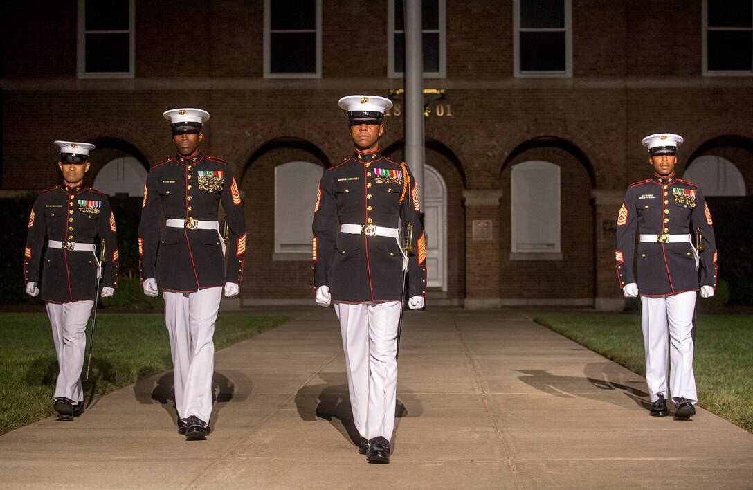 Marines of the Staff Noncommissioned Officer parade staff, Marine Barracks Washington D.C., march down center walk during the SNCO Evening Parade at the Barracks, Aug. 4, 2017. The guest of honor for the parade was retired Marine Corps Col. Archie Simpson, Guadalcanal veteran, and the hosting official was Lt. Gen. James B. Laster, director, Marine Corps Staff. (Official Marine Corps photo by Cpl. Robert Knapp/Released)