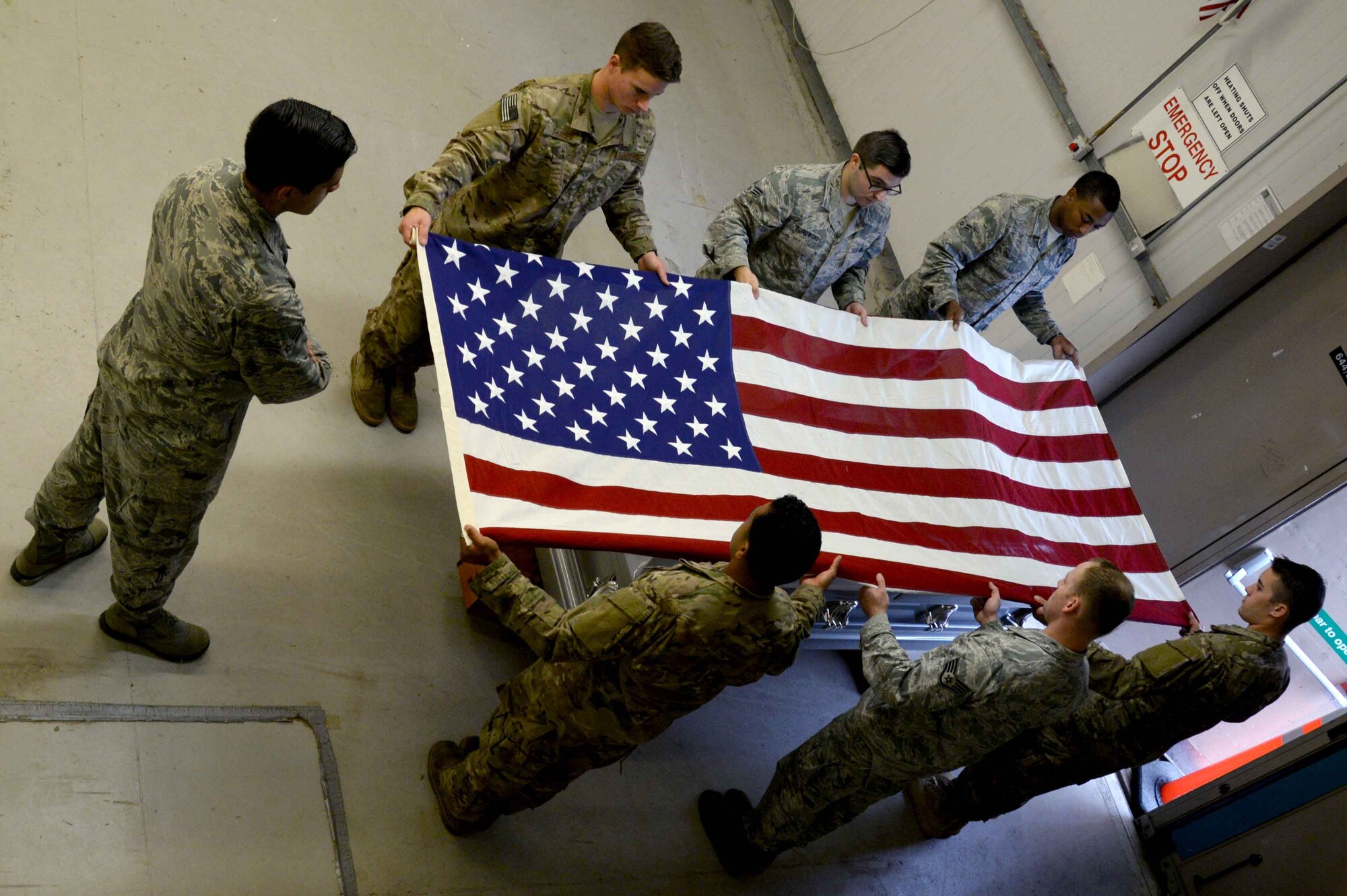 Honor guard members practice folding the flag for a funeral ceremony July 28, 2017, on RAF Mildenhall, England. Though honor guard details are priority, Team Mildenhall honor guard members must remain current and progress in their career fields. The details include changes of command, retirements and funeral ceremonies. (U.S. Air Force photo by Senior Airman Justine Rho)