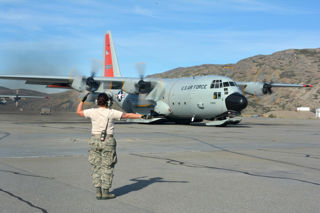 An airman marshalls an LC-130 Skibird before it takes off from Raven Camp.