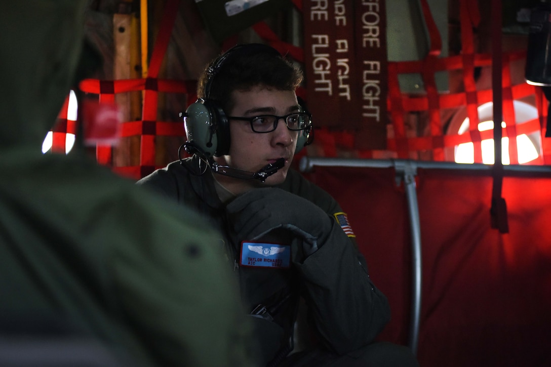 An airman reviews a loadmaster training plan during a flight to Raven Camp.