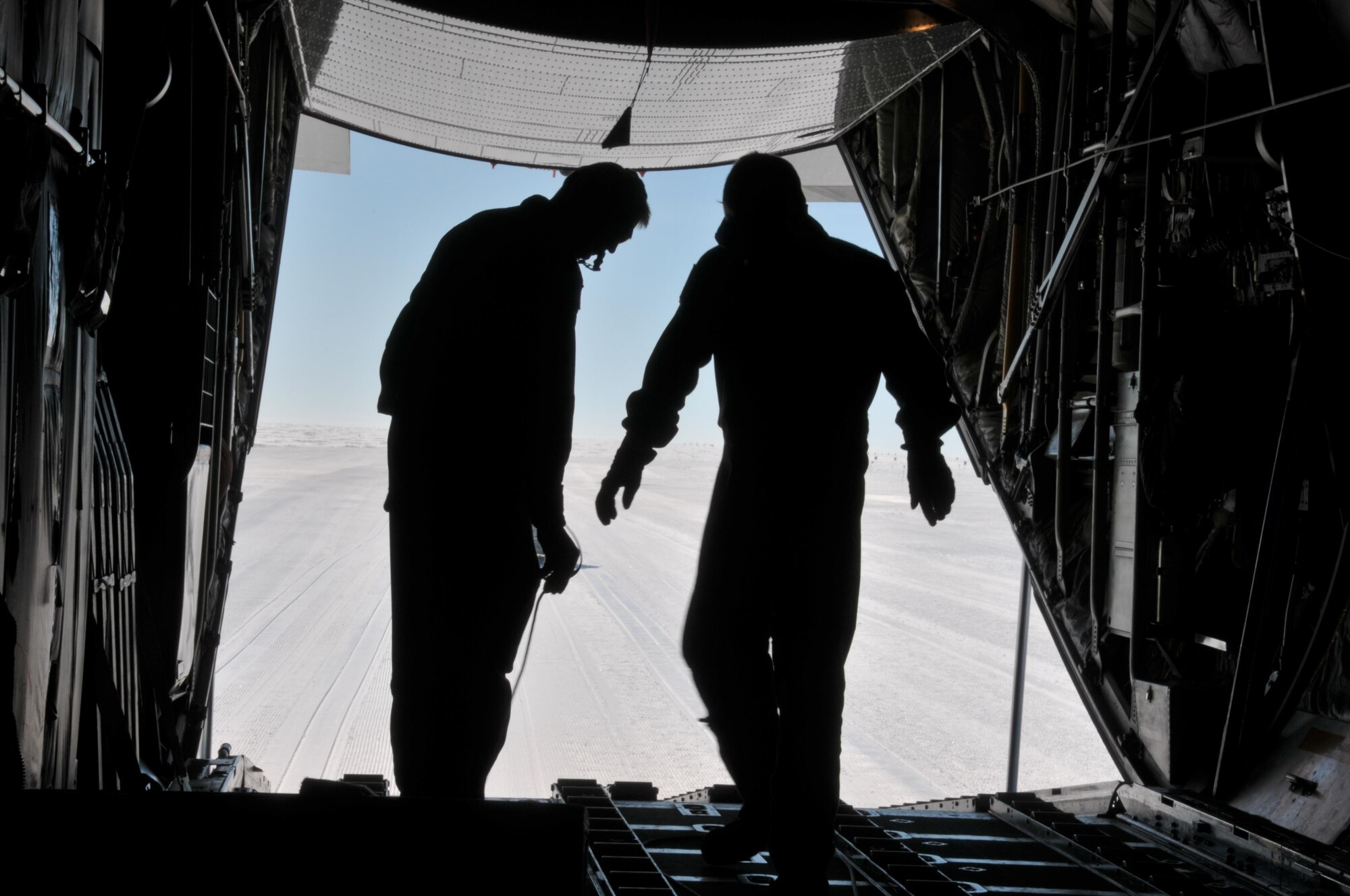 Master Sgt. Randy Powell (left) and Airman 1st Class Jason Vannostrand conduct a combat offload from an LC-130 aircraft here July 28, 2017. Powell is an instructor loadmaster with the 139th Airlift Squadron, and Vannostrand is a student loadmaster with the squadron. Raven Camp is used to train aircrews on LC-130 operations on snow runways. (U.S. Air National Guard photo by Master Sgt. Catharine Schmidt/Released)