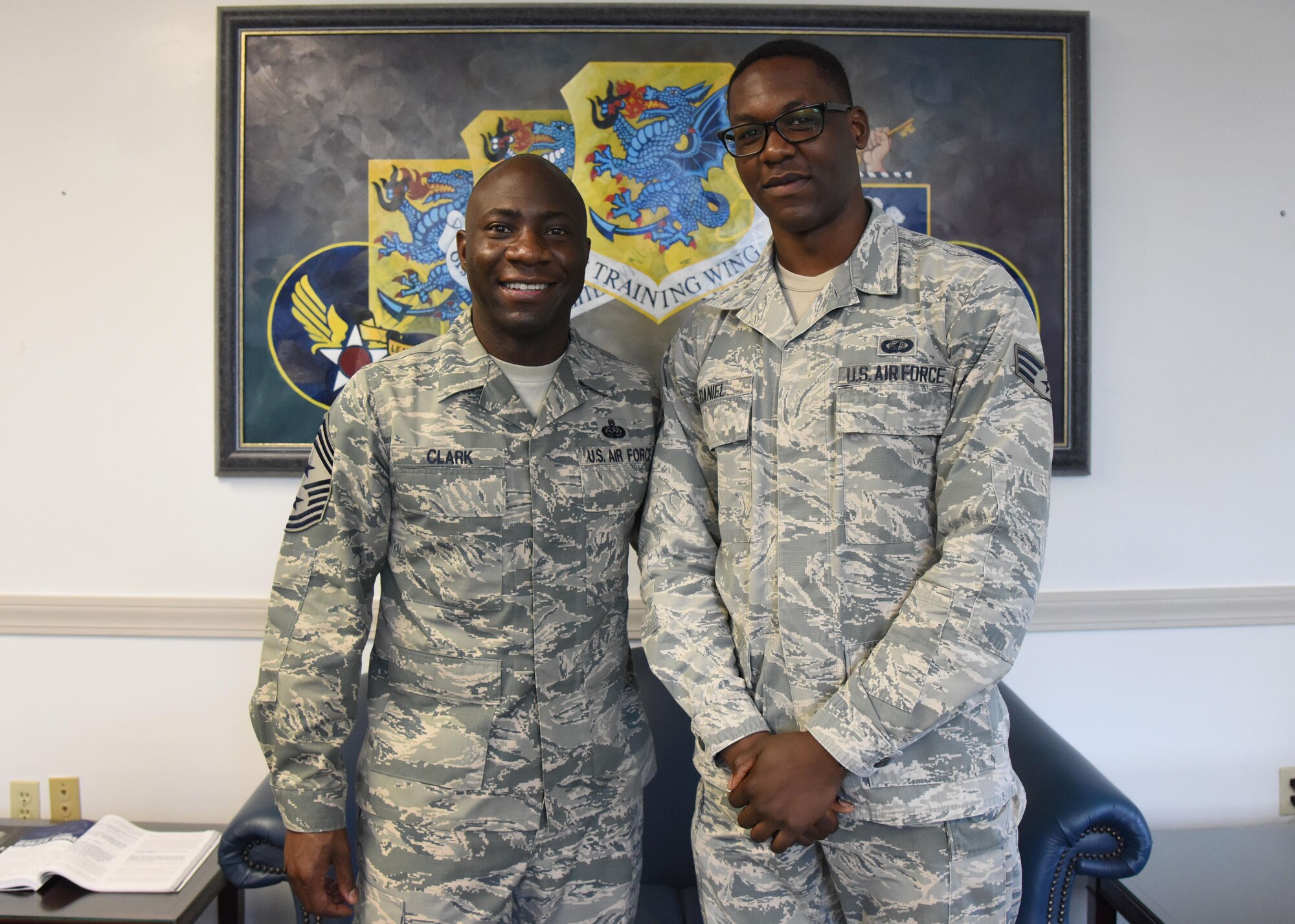 Chief Master Sgt. Vegas Clark, 81st Training Wing command chief, and Senior Airman Kadeem Daniel, 81st Contracting Squadron contract specialist, pose for a photo at the 81st TRW headquarters building Aug. 8, 2017, on Keesler Air Force Base, Miss. Daniel participated in the Command Chief for a Day program which highlights outstanding enlisted performers from around the wing. Each Airman selected for the program spends the day shadowing Clark to learn what it takes to be a command chief. (U.S. Air Force photo by Kemberly Groue)
