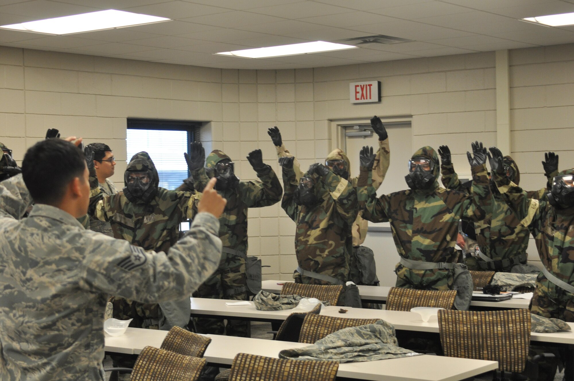 301st Fighter Wing Mission Support Group Airmen raised their hands for inspection after “suiting-up” and checking their wingman’s Mission Oriented Protective Posture (MOPP) gear during Ability to Survive and Operate (ATSO) training Saturday, Aug. 5, 2017 at Naval Air Station Fort Worth Joint Reserve Base, Texas. Annual exercises hone Airmen’s skills to continue executing the mission in austere conditions. (U.S. Air Force photo/ Tech. Sgt. Charles Taylor)
