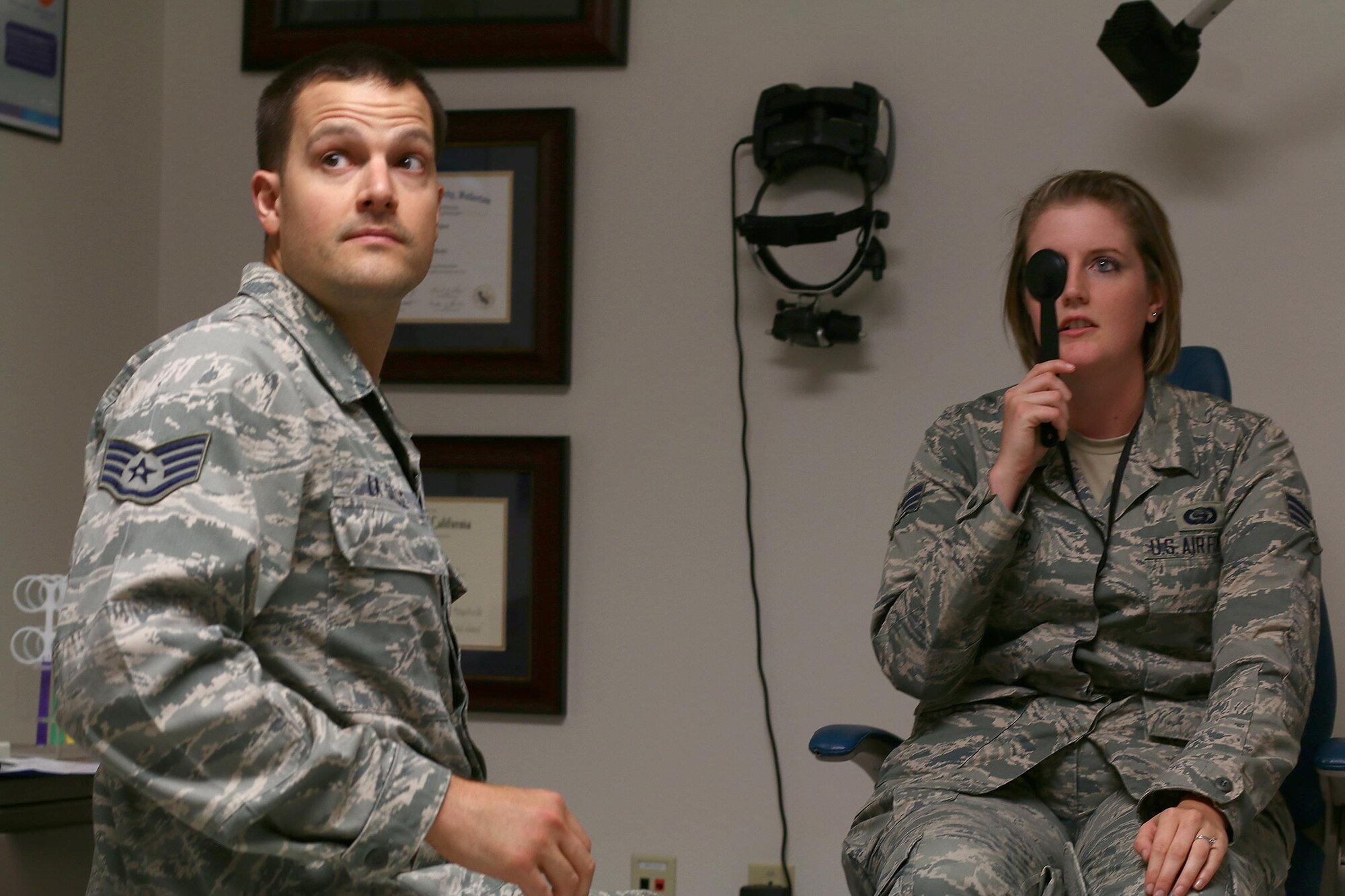 Staff Sgt. Daniel La Salle, 445th Aerospace Medicine Squadron optometry technician, conducts an eye exam with Senior Airman Jessica Rosenberger, 71st Intelligence Squadron, for a Periodic Health Assessment Services Blood Program here July 15, 2017