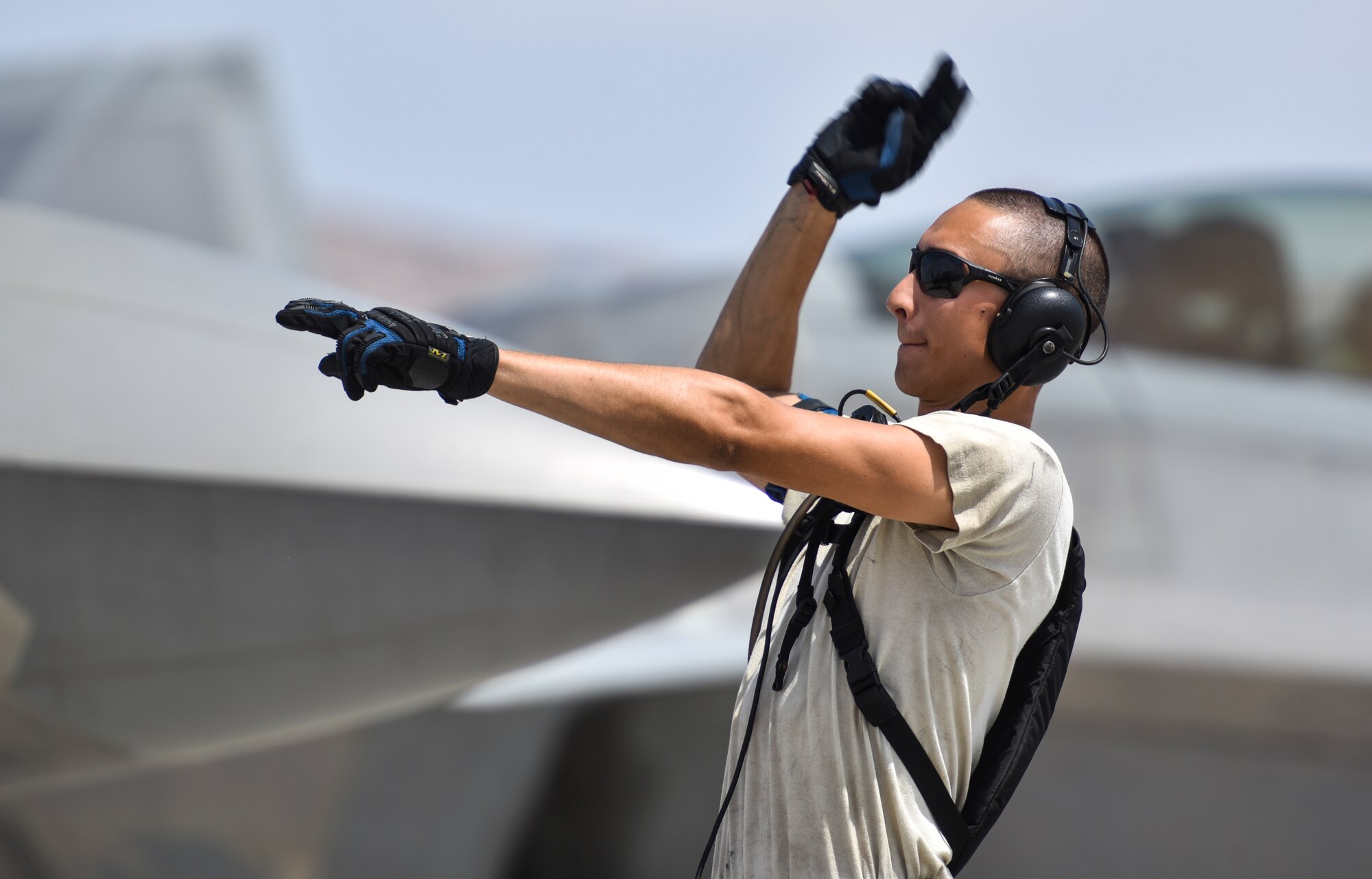 U.S. Air Force Airman 1st Class Steven Covington, crew chief from the 325th Aircraft Maintenance Squadron, Tyndall Air Force Base, Fla., signals an aircraft to begin moving on the flightline at Nellis Air Force Base, Nev., during Red Flag 17-3, July 18, 2017. Covington and other crew chiefs are responsible for preparing the jet before takeoff.