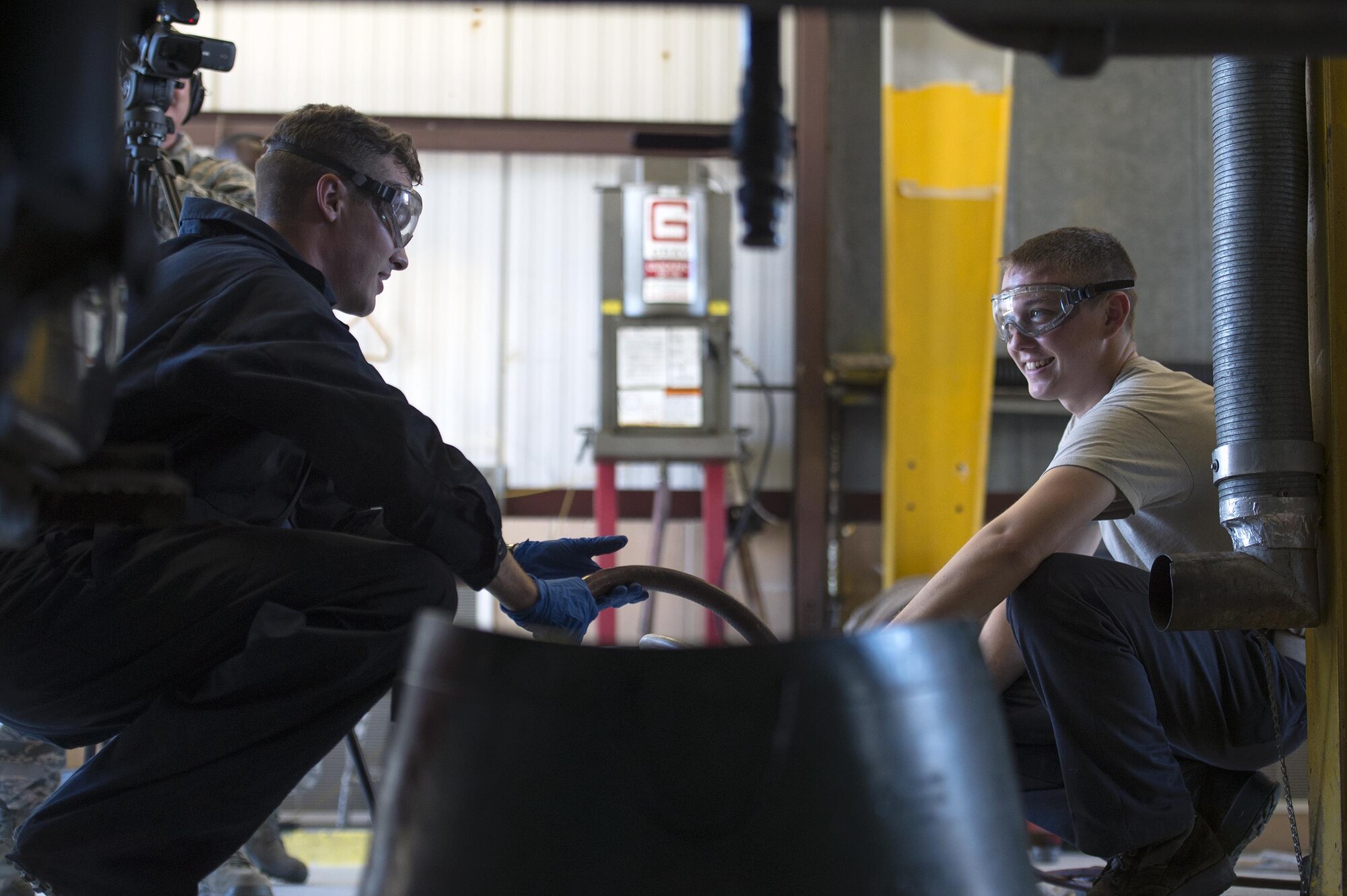 Senior Airman Kyle Saunders, 23d Wing Public Affairs broadcaster, left, interacts with Airman 1st Class Charles Price, 23d Logistics Readiness Squadron vehicle maintenance specialist, as they filter fuel during the ‘A Closer Look,’ video series, July 13, 2017, at Moody Air Force Base, Ga. The series shows 23d WG PA broadcasters experiencing the grit and grime of several trades for Airmen to better understand and appreciate different missions. To watch the series, stay tuned for the premier on the Moody Facebook page and www.moody.af.mil, August 15. (U.S. Air Force photo by Senior Airman Greg Nash)