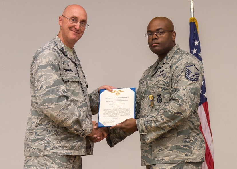 Col. George Tromba, 412th Mission Support Group commander, presents Master Sgt. Maurice Lucas II, 412th Security Forces Squadron, with the Air Force Commendation Medal (third oak leaf cluster) during a commander’s call Aug. 2 at the Edwards Air Force Base, Calif., base theater. (U.S. Air Force photo/Kyle Larson)