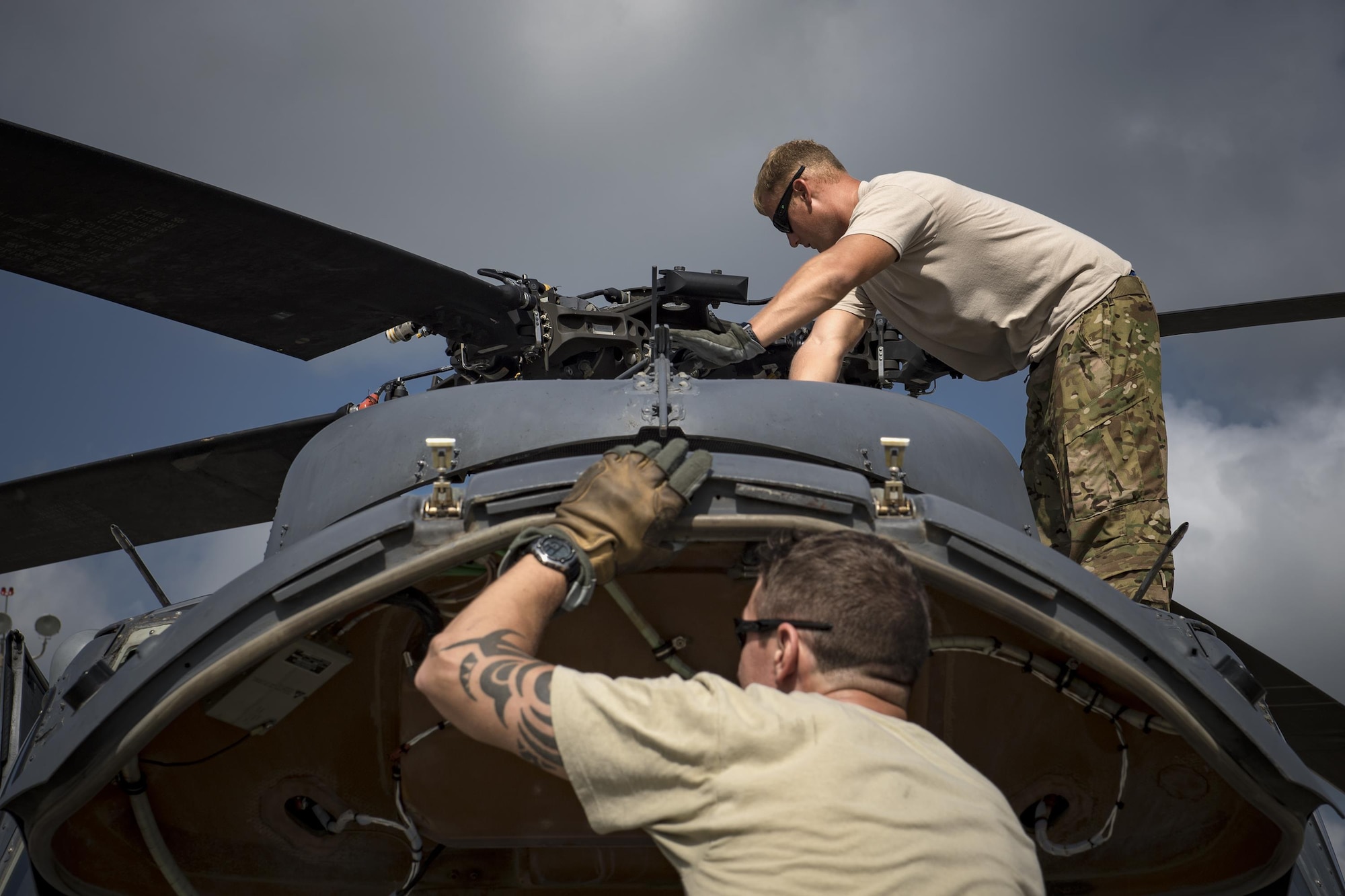Master Sgt. Joshua Emerick, front, and Master Sgt. Zachary Ferguson, 41st Rescue Squadron, special missions aviators, inspect an HH-60G Pave Hawk prior to a sortie, Aug. 7, 2017, at Moody Air Force Base, Ga.