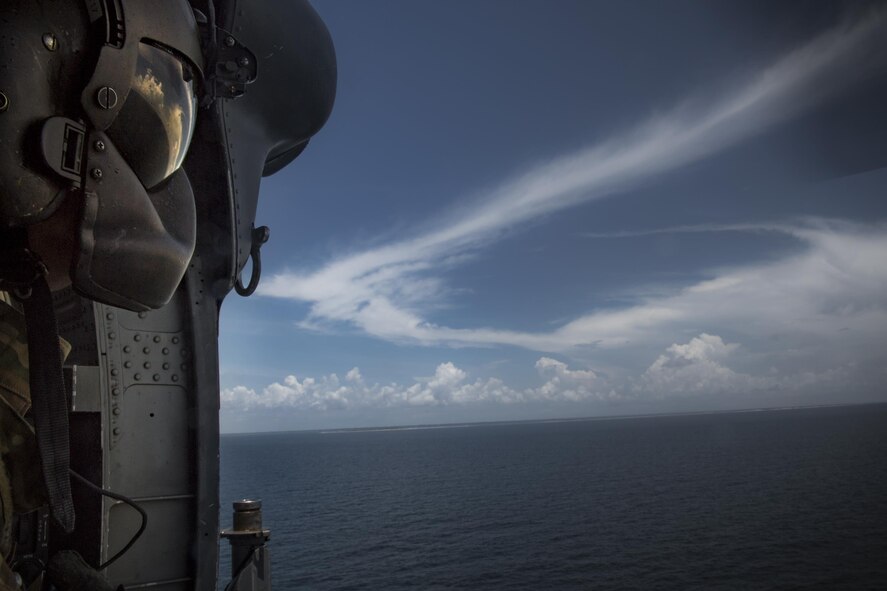 Master Sgt. Joshua Emerick, 41st Rescue Squadron special missions aviator, scans the water below prior hoisting pararescuemen into an HH-60G Pave Hawk, Aug. 7, 2017, near Dog Island, Fla.