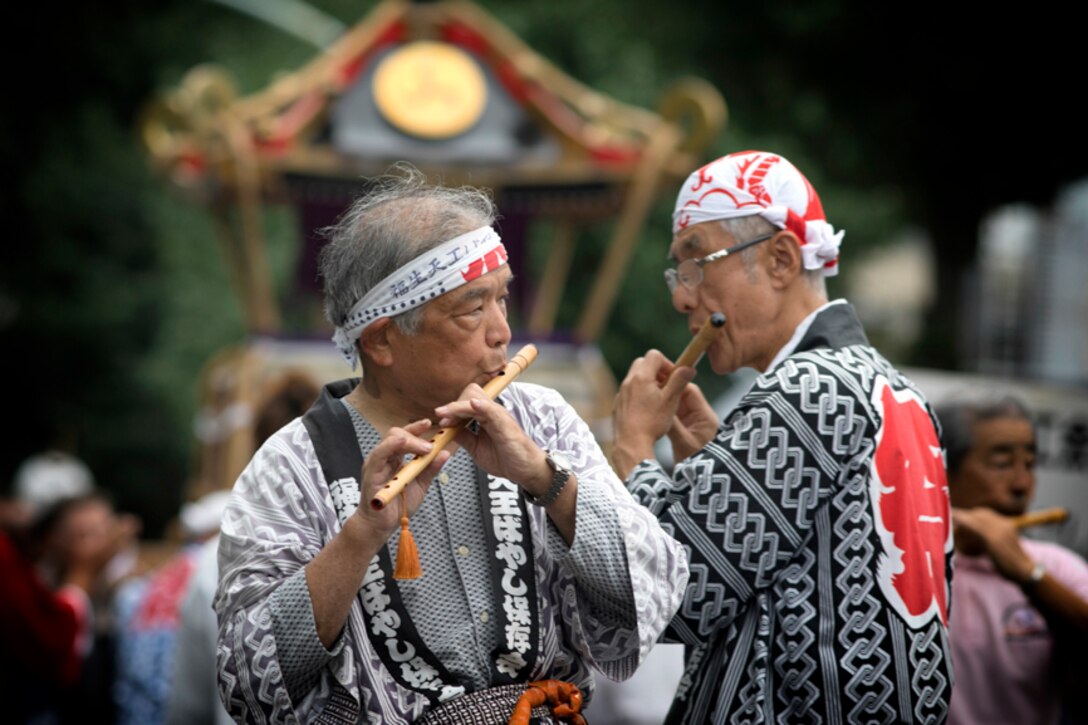Members from the Fussa Tennou Hayashi Hozonkai play Japanese flutes during the 67th Annual Fussa Tanabata Festival