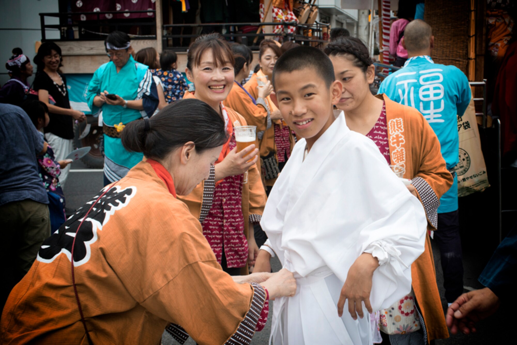 A lady from the Kumaushi Hayashi tightens a boys belt