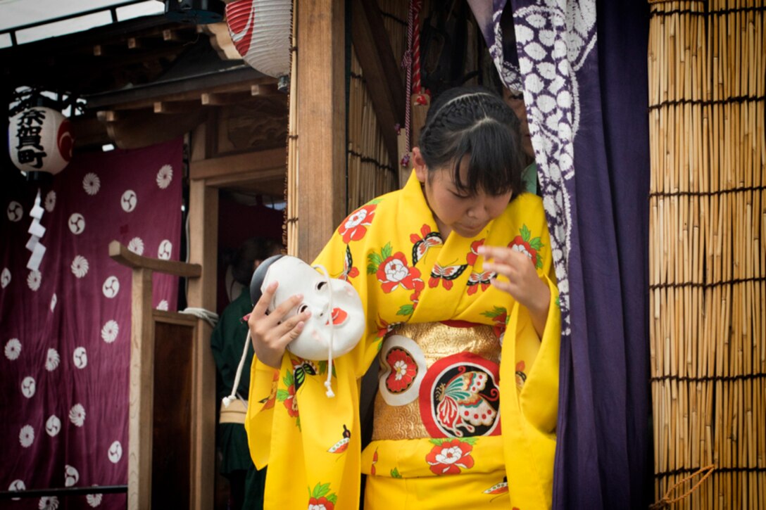 A girl from the Kumaushi Hayashi steps off of a float after Ohayashi performance