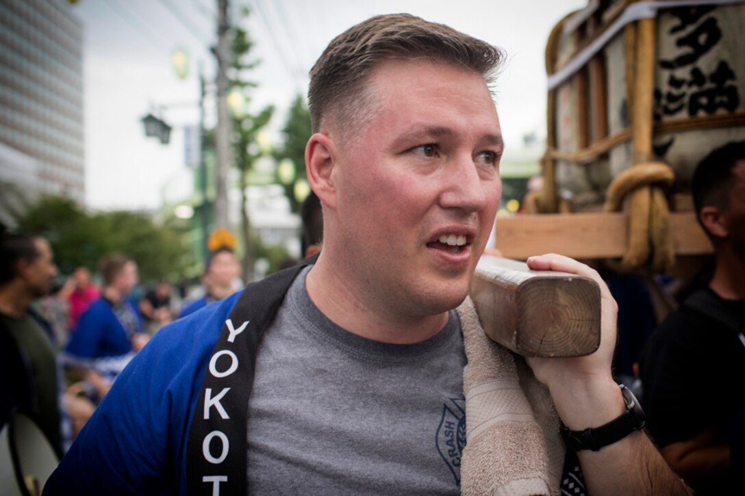Master Sgt. Eric Moses carries the wing mikoshi