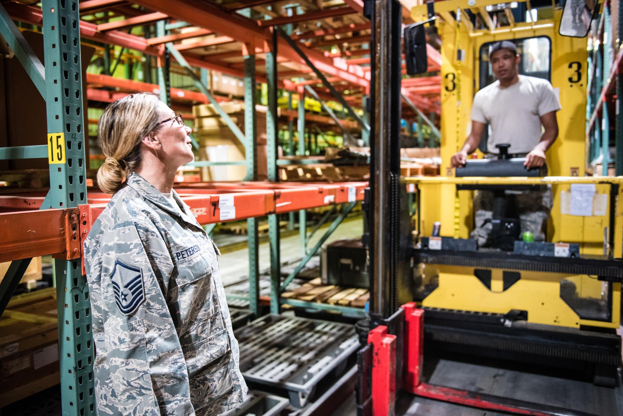 Senior Airman Donte White, 31st Logistics Readiness Squadron, walks through warehouse storage procedures with Master Sgt. Mary Peterson, 512th Logistics Readiness Squadron, July 28, 2017 at Aviano Air Force Base, Italy.