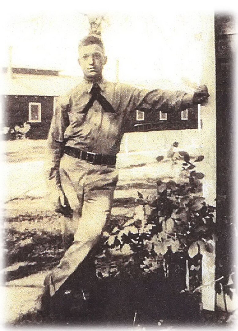 Black-and-white, WWII-era portrait of Navy sailor standing, facing viewer.