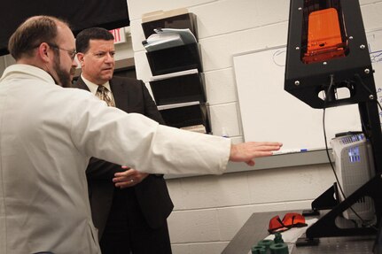 Dr. Sam Emery, a research physicist at NSWC Indian Head EOD Technology Division, discusses the command's ability to design and produce energetic materials by way of additive manufacturing with NAVSEA Executive Director James Smerchansky during his Aug. 1 visit.
