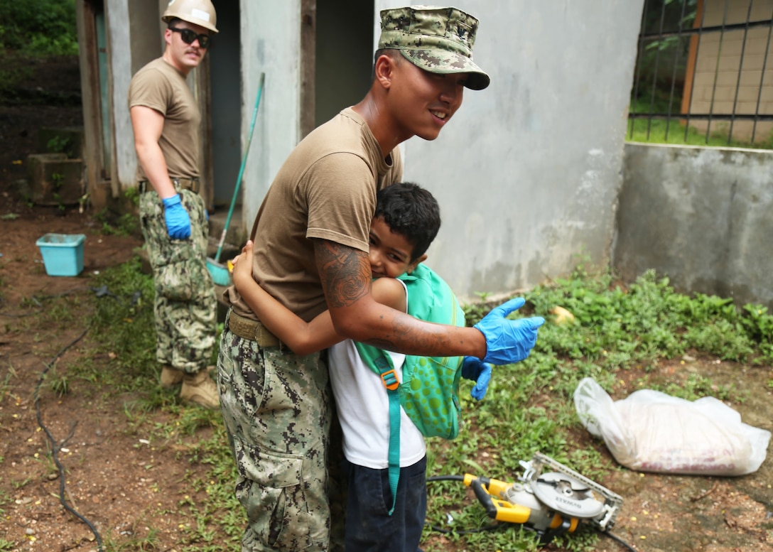 A U.S. Navy Sailor hugs a Honduran student during a Southern Partnership Station 17 community relations project at a local elementary school.