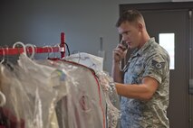 Staff Sgt. Zacheriah Merkle, 434th Civil Engineering firefighter, speaks on the phone with his girlfriend while choosing a dress for her at Grissom Air Reserve Base, Ind., July 8, 2017. Airman and Family Readiness has been accepting donations of formal dresses to be used by Airmen’s wives and girlfriends for the upcoming Air Force Ball. (U.S. Air Force photo/Senior Airman Harrison Withrow)