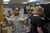 Tech. Sgt. Soyica Stanfield, A&FR technician, displays a pair of donated shoes at Grissom Air Reserve Base, Ind., July 8, 2017. Airman and Family Readiness has been accepting donations of formal dresses to be used by Airmen’s wives and girlfriends for the upcoming Air Force Ball. (U.S. Air Force photo/Senior Airman Harrison Withrow)