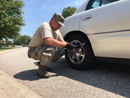 Tech. Sgt. Joseph Main, 434th Civil Engineer Squadron power production noncommissioned officer in charge, checks a vehicle’s tire pressure as part of a free vehicle inspection at Grissom Air Reserve Base, Ind., July 5, 2017. Main checked tire pressure, made pressure adjustments as needed and looked under the hood to check oil levels and point out any potential problems. (U.S. Air Force photo/Senior Airman Cali Wetli)