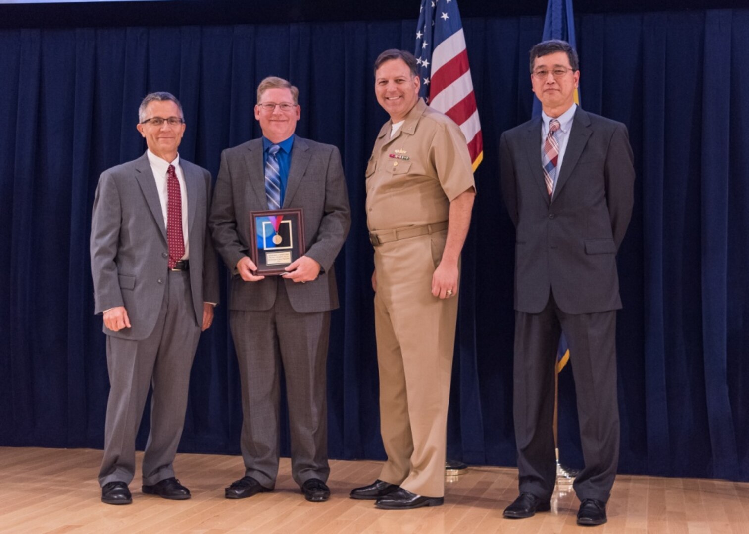 Richard Loeffler, the program manager for advanced signature guidance and training systems, receives the Capt. Harold E. Saunders Award for exemplary technical management at the Naval Surface Warfare Center, Carderock Division Honor Awards ceremony Aug. 1, 2017, in West Bethesda, Md. From left to right: Technical Director Dr. Tim Arcano, Loeffler, Commanding Officer Capt. Mark Vandroff and Ship Signatures Department Head Dr. Paul Shang. (U.S. Navy photo by Jake Cirksena/Released)