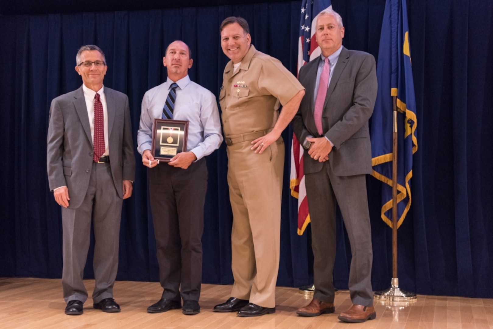 Lawrence Michelon, a senior electronics engineer for the Systems Design and Integration Branch at Carderock™s Combatant Craft Division in Norfolk, receives the Rear Adm. George W. Melville Award for engineering excellence at the Naval Surface Warfare Center, Carderock Division Honor Awards ceremony Aug. 1, 2017, in West Bethesda, Md. From left to right: Technical Director Dr. Tim Arcano, Michelon, Commanding Officer Capt. Mark Vandroff and Naval Architecture and Engineering Department Head Mike Brown. (U.S. Navy photo by Jake Cirksena/Released)