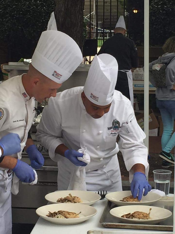 A food service chief for the 26th Marine Expeditionary Unit prepares entrée plates.