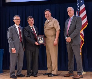 Dr. Vadim Belenky, a naval architect with Carderocks Simulations and Analysis Branch, receives the Rear Adm. David W. Taylor Award for outstanding scientific achievement at the Naval Surface Warfare Center, Carderock Division Honor Awards ceremony Aug. 1, 2017, in West Bethesda, Md. From left to right: Technical Director Dr. Tim Arcano, Belenky, Commanding Officer Capt. Mark Vandroff and Naval Architecture and Engineering Department Head Mike Brown. (U.S. Navy photo by Jake Cirksena/Released)